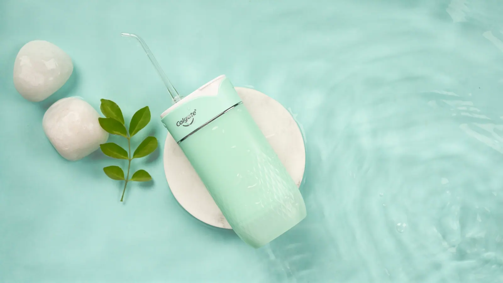 Water flosser on marble in shallow water with stones and a leaf